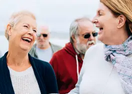 Two women laughing, two men walking in the background, as if they've just shared a joke about their recent visit to the local denture clinic.