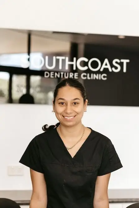 Woman in black scrubs smiling outside Southcoast Denture Clinic, your Gold Coast denture clinic.