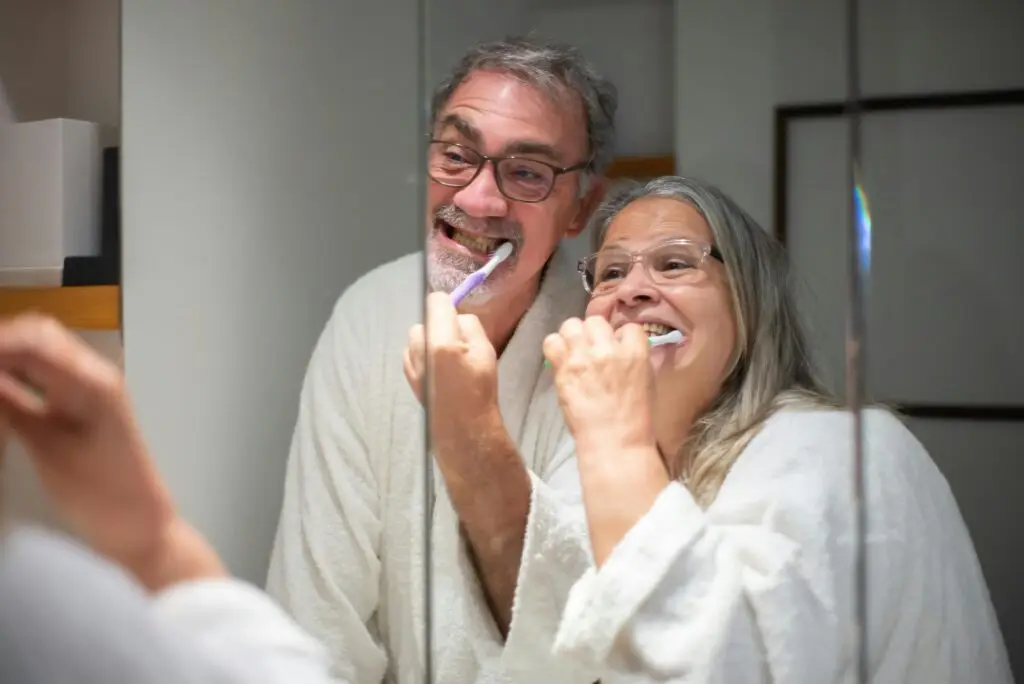 older couple brushing their dentures
