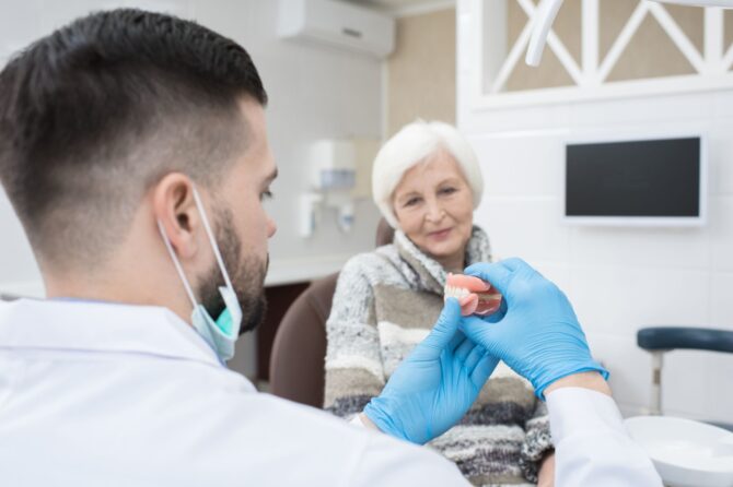 Dentist discussing the fit of tight dentures with an older patient